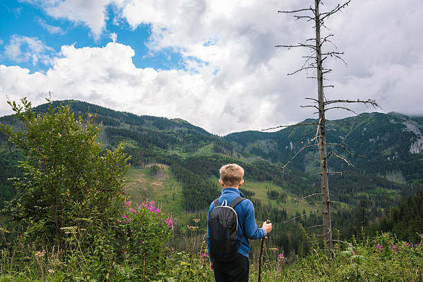 istock Boy looking at a beautiful view in the mountains 2208469210