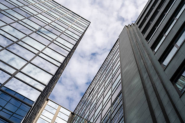 istock Modern Glass Office Building with Reflective Facade Against a Cloudy Sky 2208469795