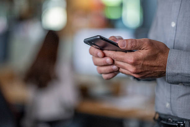istock Close Up of Businessman Using Smartphone in Modern Office Setting 2208469908