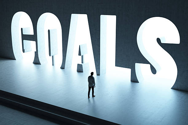 istock Man Standing in Front of Glowing GAOLS Word Structure 2208471958