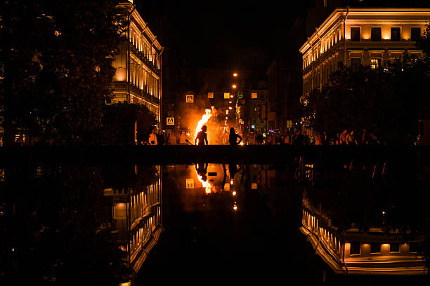 Russia, St. Petersburg - August 08, 2024. Night fire show on the city street, beautifully reflected in the water of the fountain.