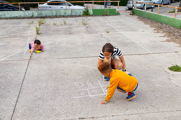 istock Children drawing with chalk on the ground in a playground 2208476131