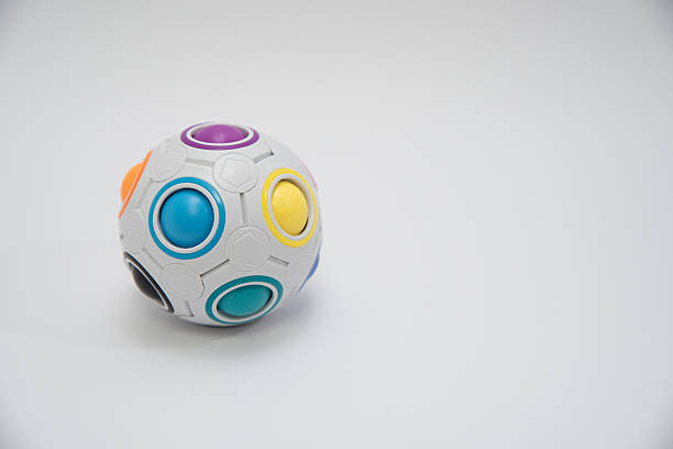 A modern generic moulded soccer football with a color pattern and dimple texture resting on a stand on an isolated studio backgrund - 3D render