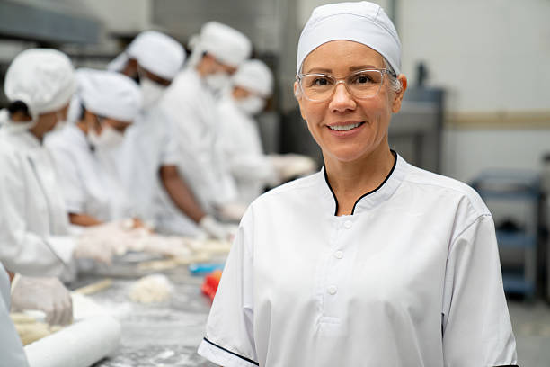 istock Happy baker working at an industrial bakery and smiling 2208483774