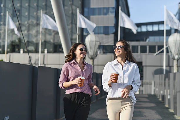 istock Two Females Running Towards University in Hurry While Holding Coffee Cups 2208485826
