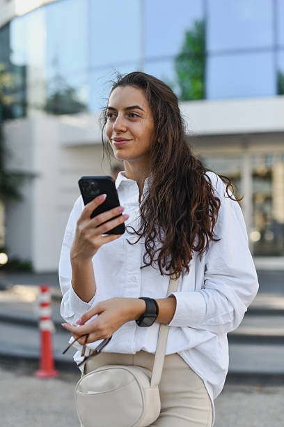 istock Woman Getting Distracted by Friend Approaching While Texting on Her Phone 2208486652
