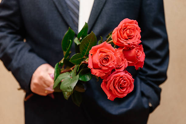 istock bouquet of five red roses in man hands 2208489079