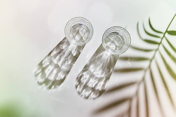 istock Water Glasses with palm leaf Shadow and sunlight Reflection on white background, colored photo minimal style, aesthetic top view summer still life, refraction throug crystal shine cups, caustic 2208489744
