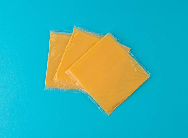 istock American cheese, processed cheese slice, wrapped thin yellow cheddar in a plastic package 2208492609
