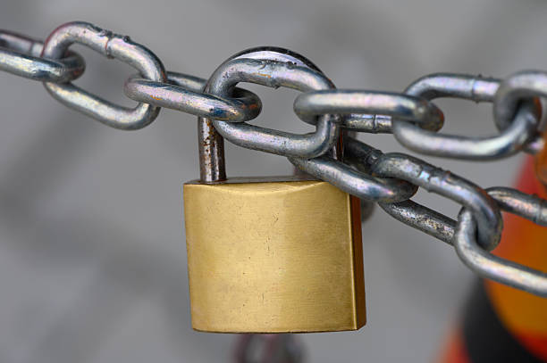 istock Locked securely, ensuring safety with a sturdy padlock on a chain link, representing protection in an urban environment 2208497278