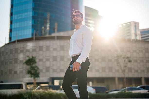 istock Confident Middle Eastern Businessman Walking Outdoors in Dubai's Urban Skyline 2208500697