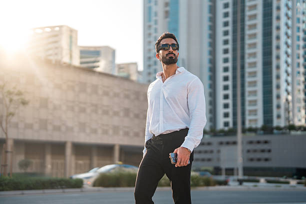 istock Young Middle Eastern Professional Standing Near Modern Dubai Skyscrapers at Sunset 2208500725