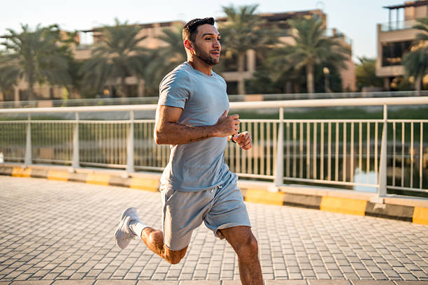 Focused Hispanic Man Running Outdoors in Dubai at Sunrise