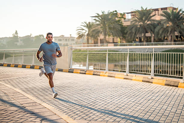 istock Focused Hispanic Male Running in Dubai at Sunrise on a Cobblestone Path 2208501136
