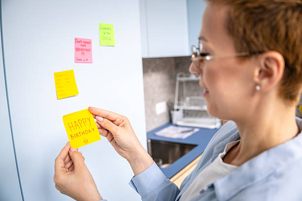 istock Creative individual organizing sticky notes on a modern office wall with colorful reminders and messages for efficient planning 2208502124