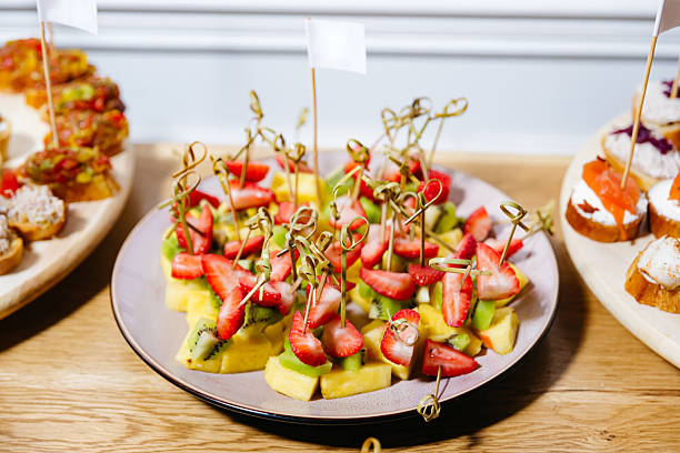 Fresh fruit skewers with pineapple, kiwi, and strawberries served on a plate, perfect for party or catering events.