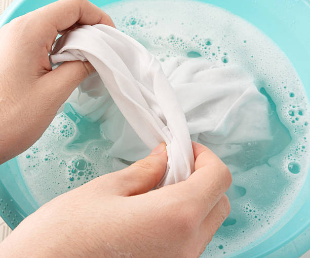 istock Hand laundry washing clothes in blue plastic basin 2208508689