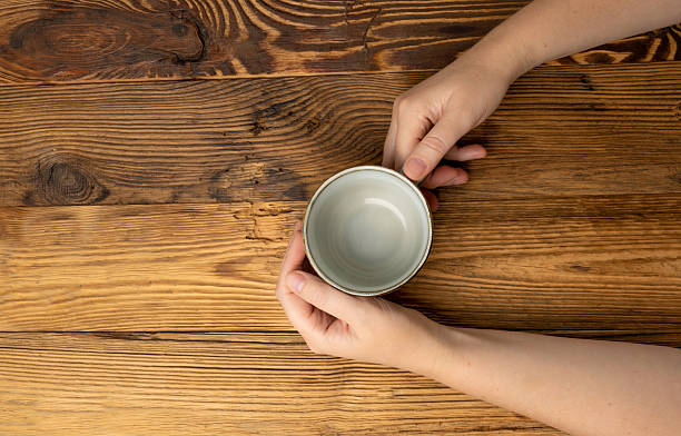 istock Hand Holds Cup, Empty Cup in Hands, Coffee Mug, Teacup Mockup, Cup in Arms on Wooden Table 2208508992