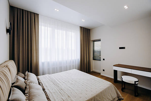 istock A cozy bedroom with a bed, desk, elegant curtains, and light 2208512420