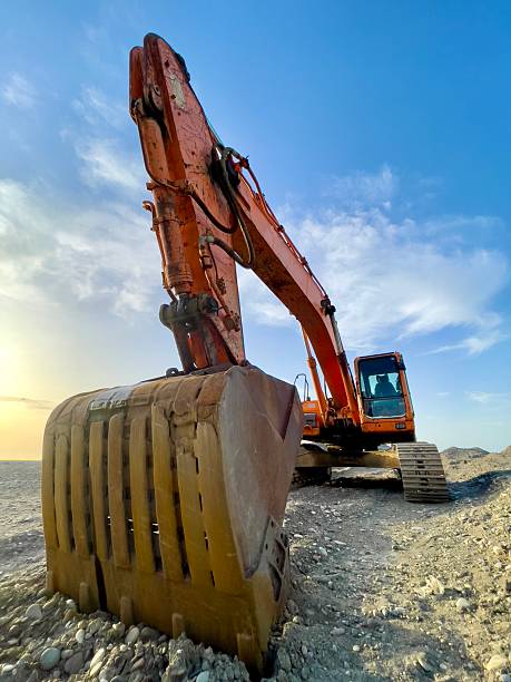istock Orange Excavator Operating on Rocky Terrain Under a Blue Sky 2208513056