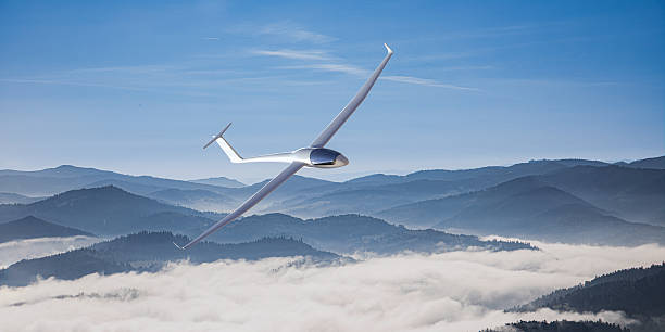A sleek glider soaring over misty mountain peaks
