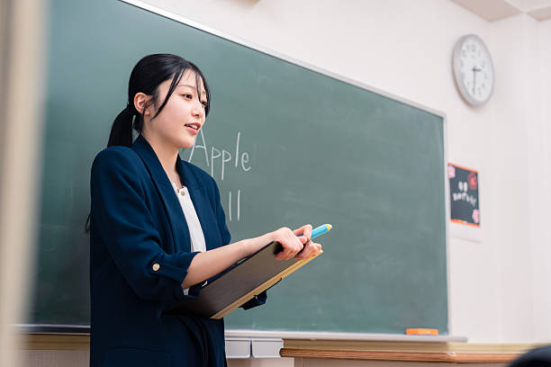 istock Female teacher teaching English at school 2208516346