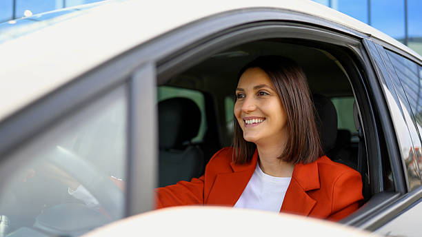 istock Young businesswoman smiling while driving her car 2208519417