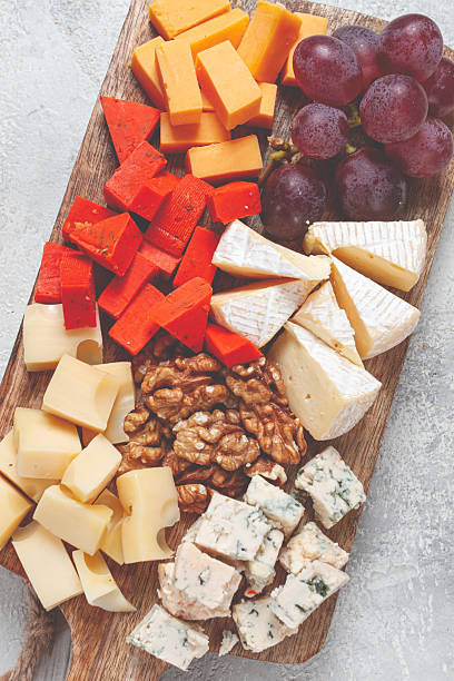 istock Assorted cheese on a wooden board, with grapes and walnuts, appetizer, no people. 2208525150