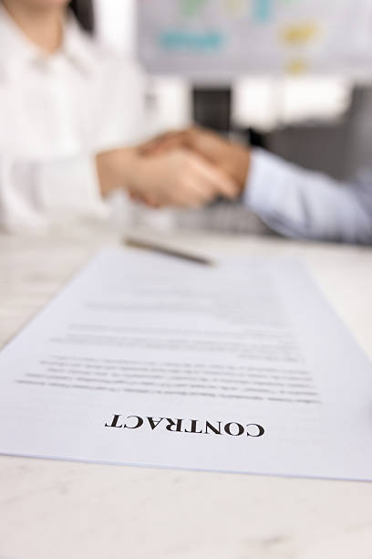 istock Close up of contract on table with two business partners 2208525814