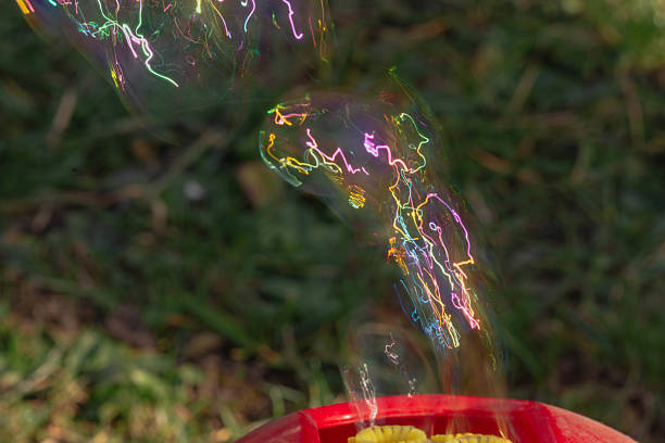A beautiful little girl with Down syndrome learns to blow soap bubbles. Blow through a tube. Speech therapy exercises