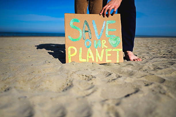 istock Activists placing save our planet sign on the beach 2208533034