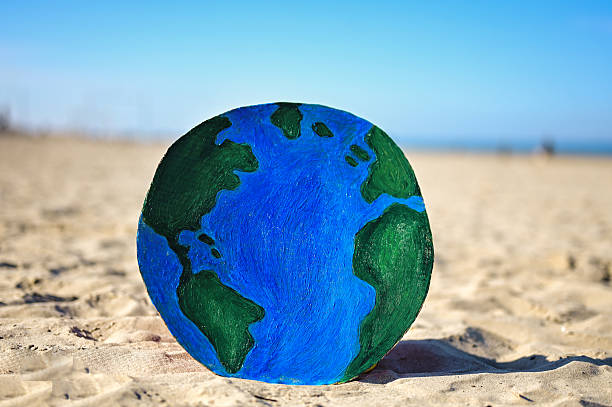 Protecting our planet: earth drawing on a sandy beach raises awareness