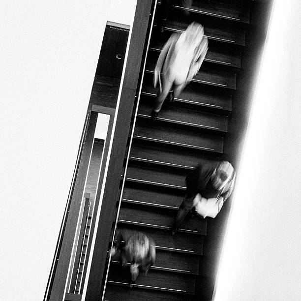 istock abstract minimalist long exposure of unrecognizable people walking down a staircase 2208535225