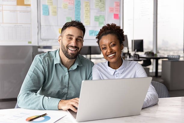 Happy young diverse business partners posing for portrait in office