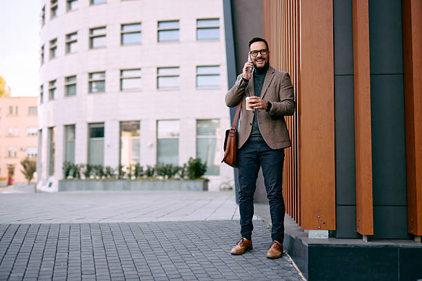 istock Businessman talking on the phone and drinking coffee outside the office 2208538775