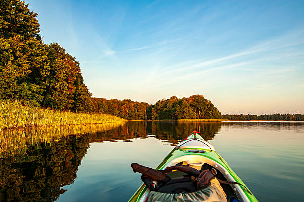 Rowboat with oars left on the shore of a lake during the summer holiday season, with sunlight. Holidays activities. This is a great way to spend your holidays actively at the lake.