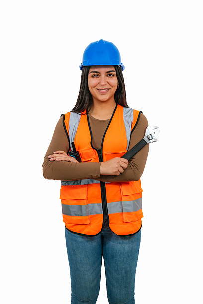 istock Confident Latina construction worker smiling with crossed arms and holding an adjustable wrench 2208543043