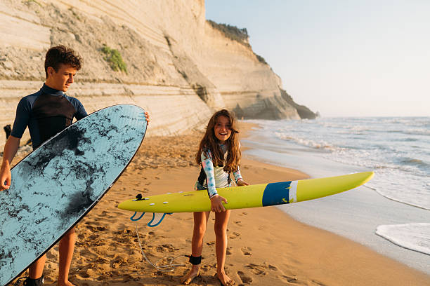 istock Young Surfers Embracing the Sunset Waves 2208545191