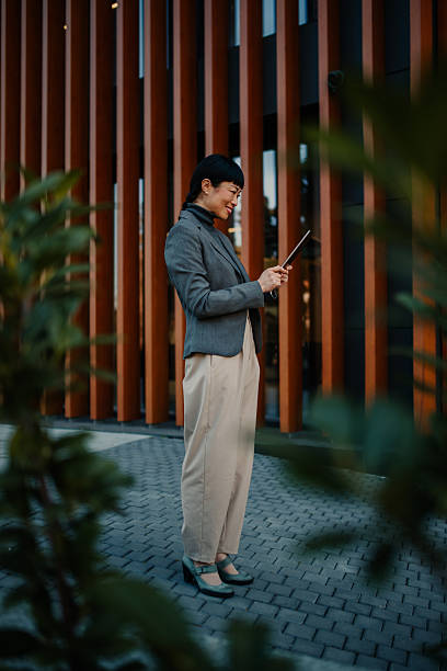 Businesswoman using digital tablet outside modern office building