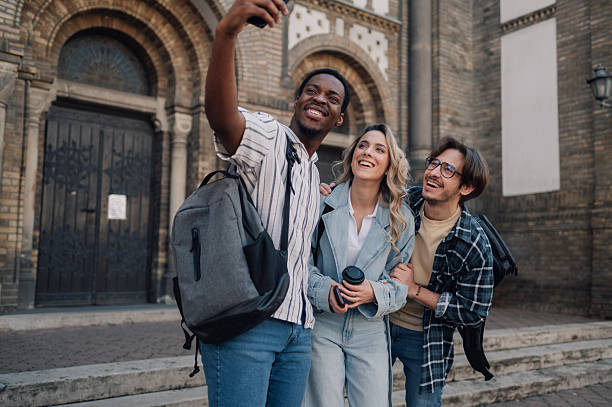 istock Three happy students taking a selfie in front of a church 2208546163