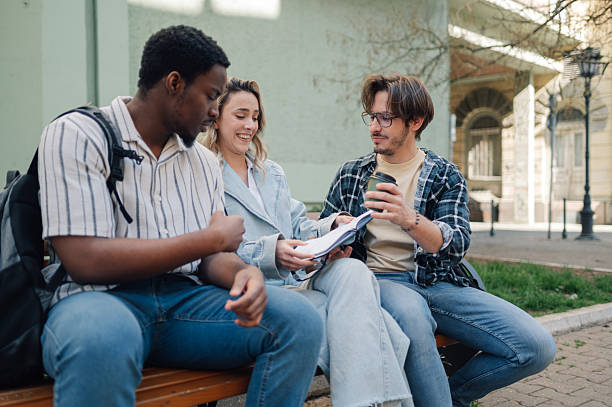 istock University students studying together on bench and sharing ideas 2208546171