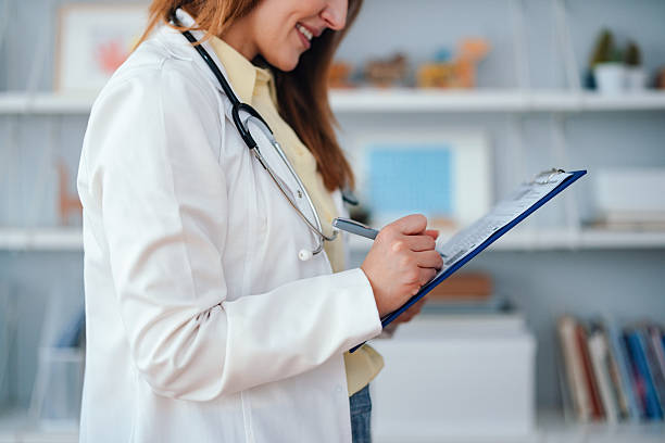 istock Friendly Female Doctor Documenting Records in a Modern Medical Office 2208547104