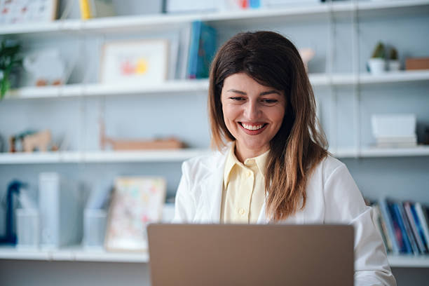 istock Smiling Professional in Modern Office Engaged with Work on Laptop 2208547112