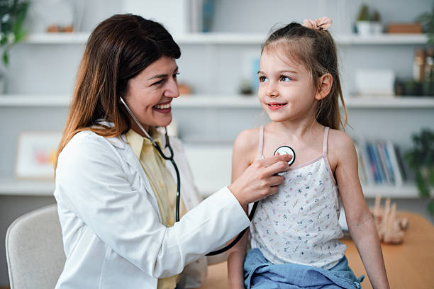 istock Smiling Female Doctor Examining a Child with a Stethoscope During Checkup 2208547162