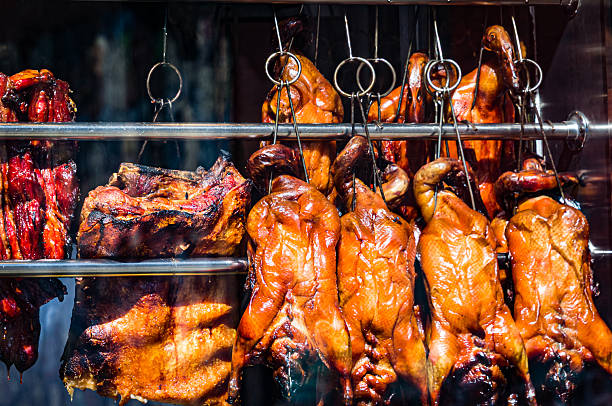 Fresh cooked meats hang in the window of an Asian food store in Boston's Chinatown.