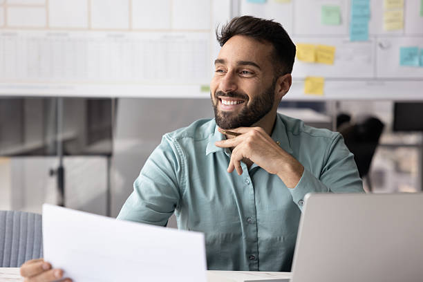 istock Happy successful Latin manager man analyzing financial report at workplace 2208547750