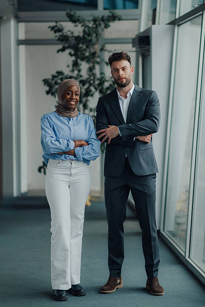 istock Two confident business professionals smiling with folded arms in modern office 2208547911