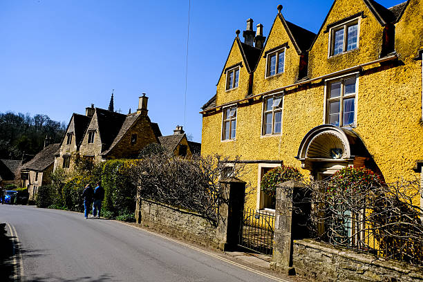 Castle Combe, Cotswolds, UK - 01.04.2025. The Street view of Castle Combe, Cotswolds. Small village in the English countryside. Facade of old medieval house, charming village cottage, located at The Street.
