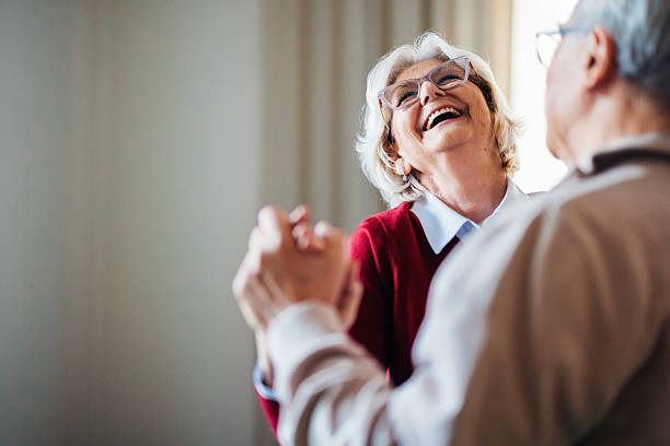 Happy Elderly Couple Dancing Together in a Bright Room