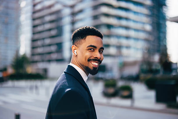 istock Smiling Man Enjoying Walk in Urban Area Wearing Wireless Earbuds 2208552069